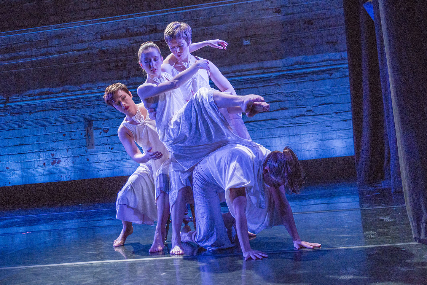 Image of 4 MorrisonDancers in front of a blue background wearing white gowns